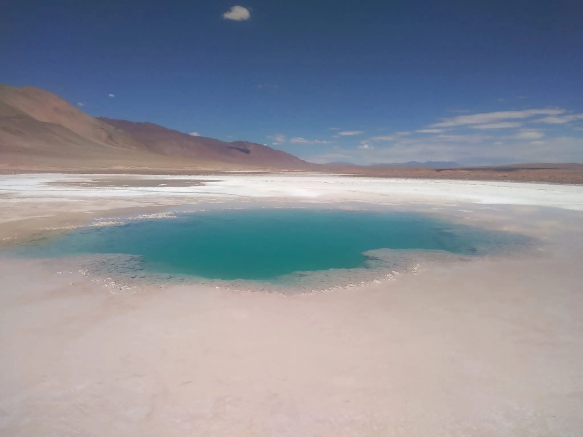Laguna de agua turquesa rodeada de salar blanco, camino al Balcón del Pissis