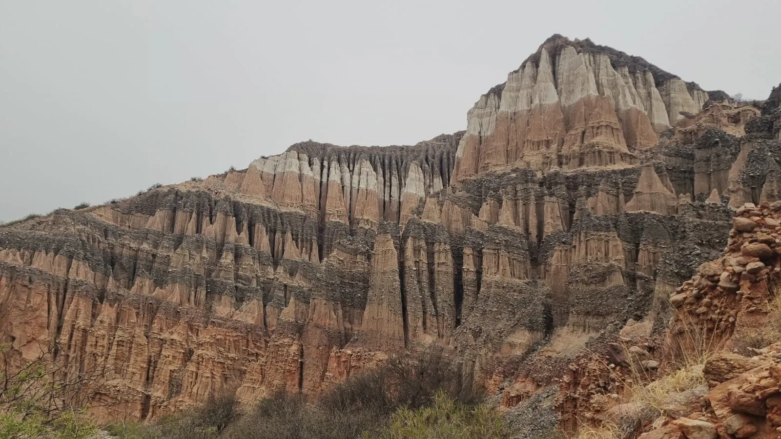 Paredes de roca roja y rosada con torres y columnas talladas por la erosión, bajo un cielo nublado en los Castillos de Villa Vil