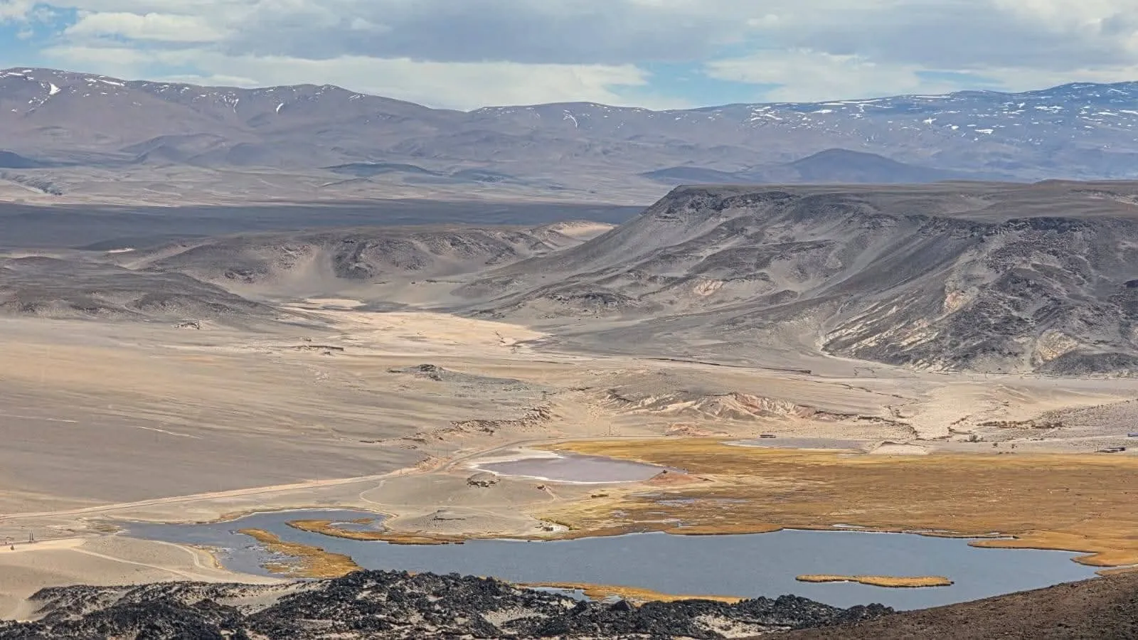 Vista desde el volcán a una laguna y a los cerros de colores de la puna